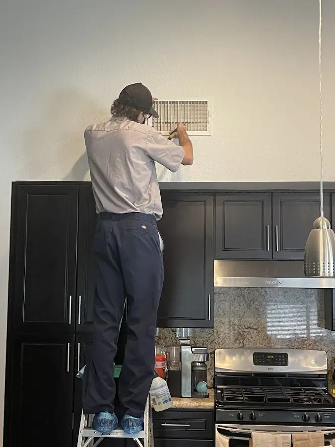 Technician inspecting an air vent during HVAC service in Terrace Heights